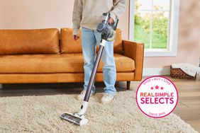 A person using the Tineco Pure One S11 Tango Smart Stick Handheld Vacuum on a rug