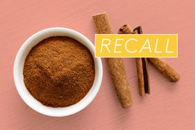 ground cinnamon in a bowl next to cinnamon sticks and a recall sticker