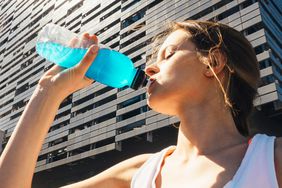 What-are-electrolytes: woman drinking a sports drink while exercising