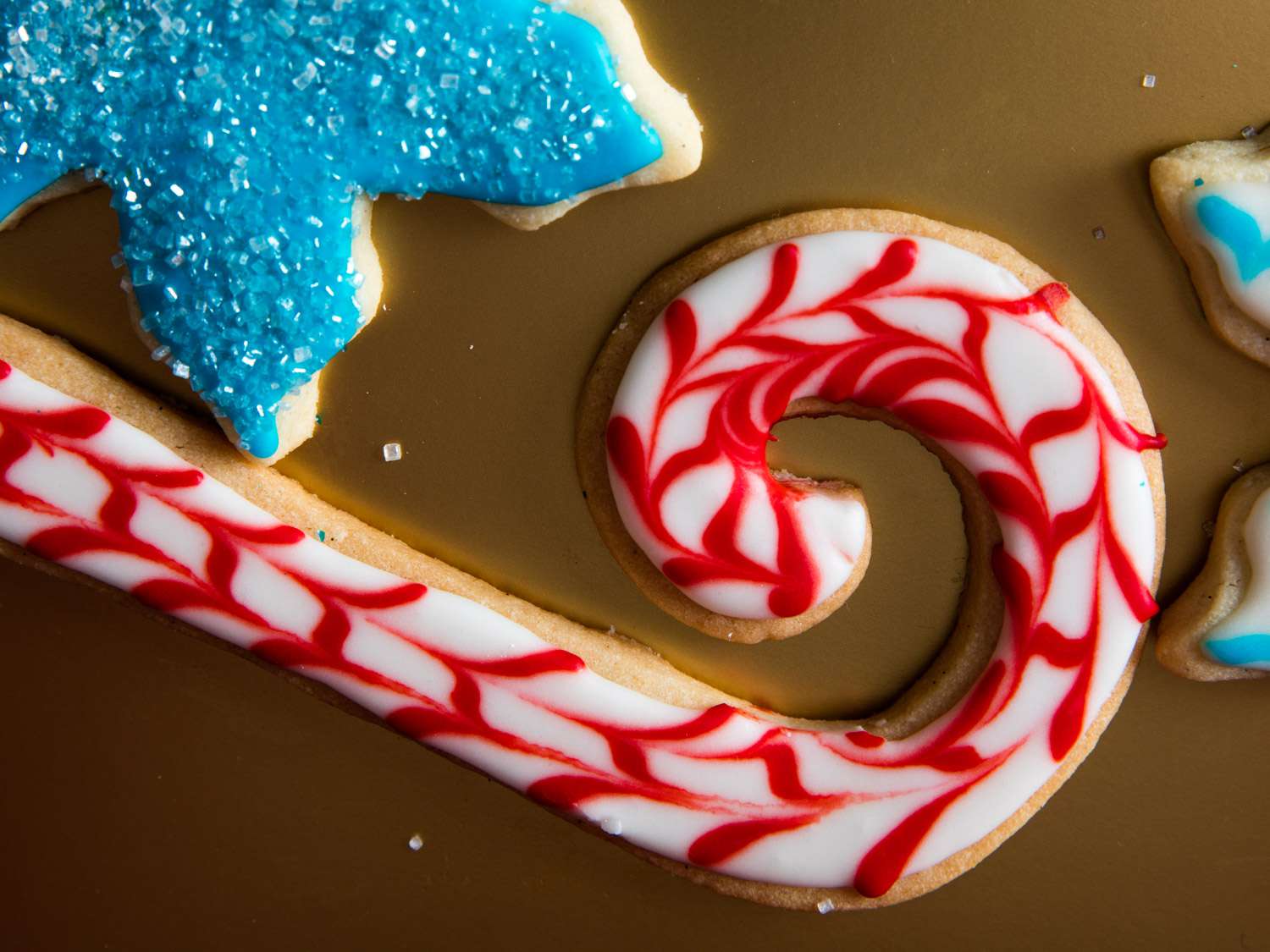 Close-up of a cookie cut and decorated to resemble a candy cane.