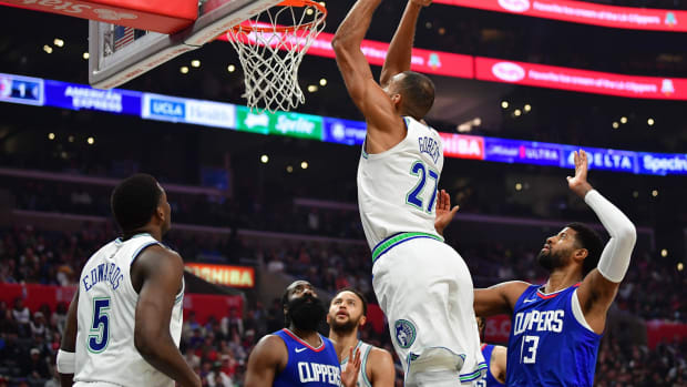 Mar 12, 2024; Los Angeles, California, USA; Minnesota Timberwolves center Rudy Gobert (27) moves in for the dunk against Los Angeles Clippers forward Paul George (13) during the first half at Crypto.com Arena.