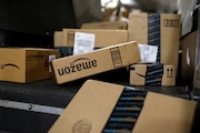 In this Nov. 20, 2015, file photo, packages being shipped in Amazon boxes ride a conveyor belt at the a facility in Louisville, Ky.