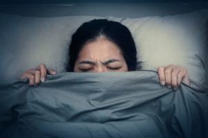 stock photo of a woman raising blanket over her face