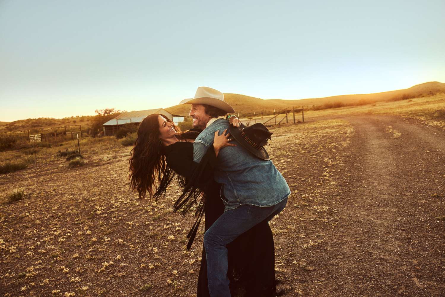 Matthew and Camila McConaughey in Marfa, Texas; Camila's dress and belt by Roberto Cavalli; Jewelry by Jacquie Aiche; Camila's hat by Ras Redwine Hats