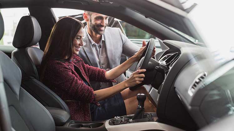 With his daughter behind the wheel of a parked car, a dad offers instruction.