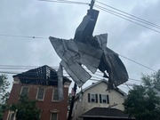 A large section of metal roof torn from a building was wrapped around a utility pole.