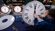 Ian Roders fastens the hands to a clock at Electric Time Company, Tuesday, Nov. 1, 2022, in Medfield, Mass. Daylight Saving Time 2024 ends soon. (AP Photo/Charles Krupa)