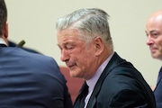 Actor Alec Baldwin, center, reacts as he sits between his attorneys Alex Spiro, left, and Luke Nikas after the judge threw out the involuntary manslaughter case for the 2021 fatal shooting of cinematographer Halyna Hutchins during filming of the Western movie "Rust," Friday, July 12, 2024, in Santa Fe, N.M. (Ramsay de Give/Pool Photo via AP, File)