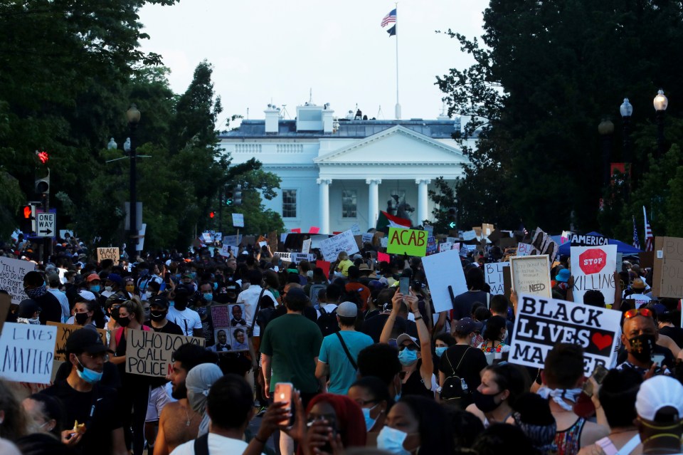  Demonstrators hold up signs at the "Black Lives Matter Plaza", near the White House, during a protest against racial inequality