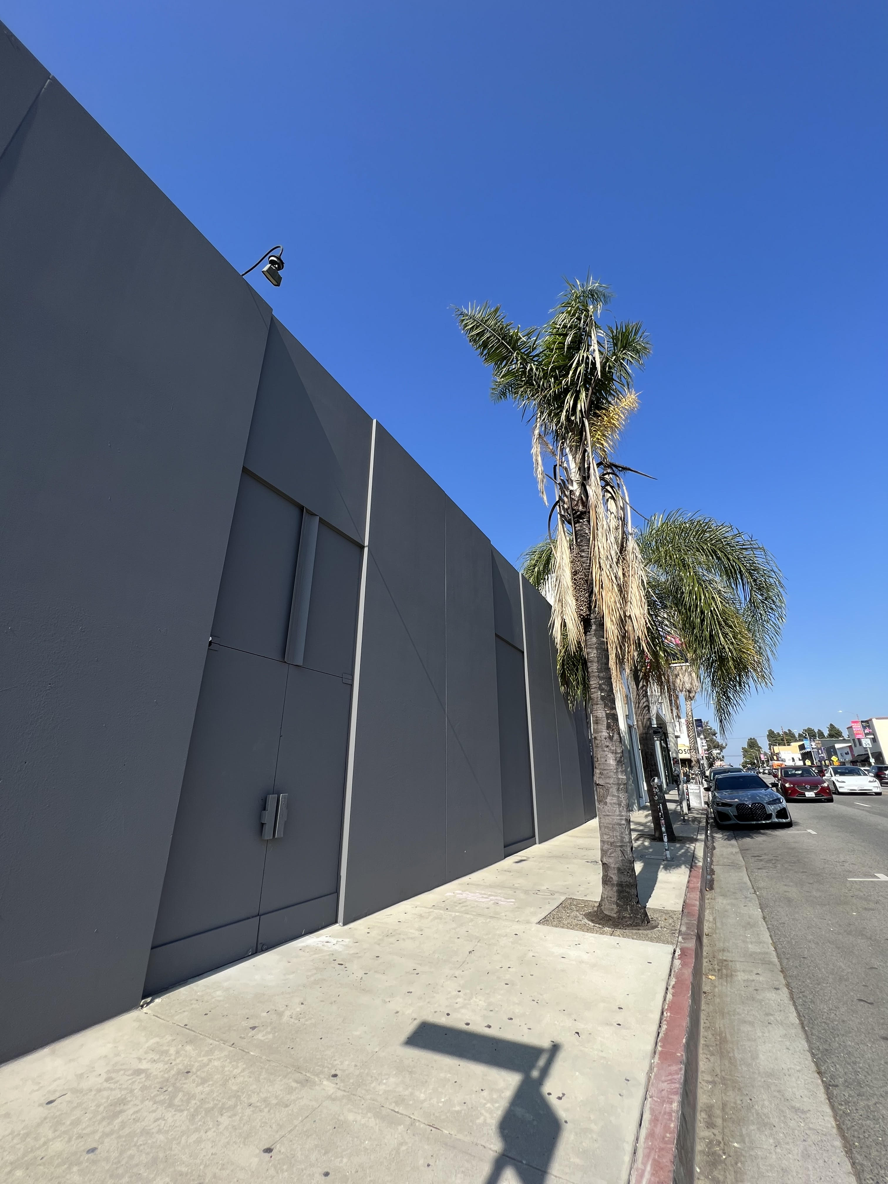 The windows and doors of the warehouse space have been covered and the building has been painted gray