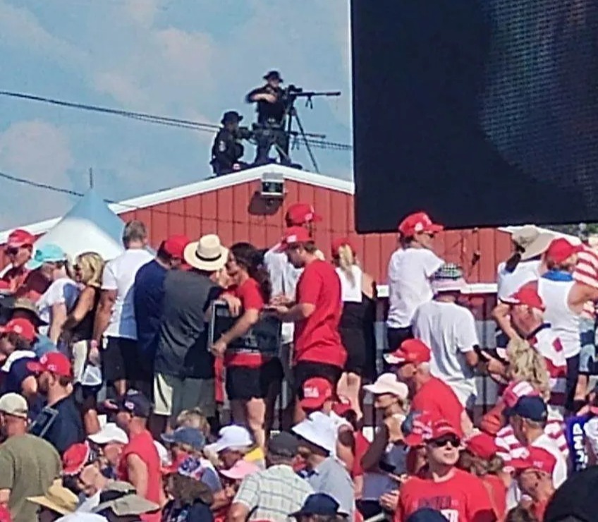 Sniper officials stand on a roof at the rally