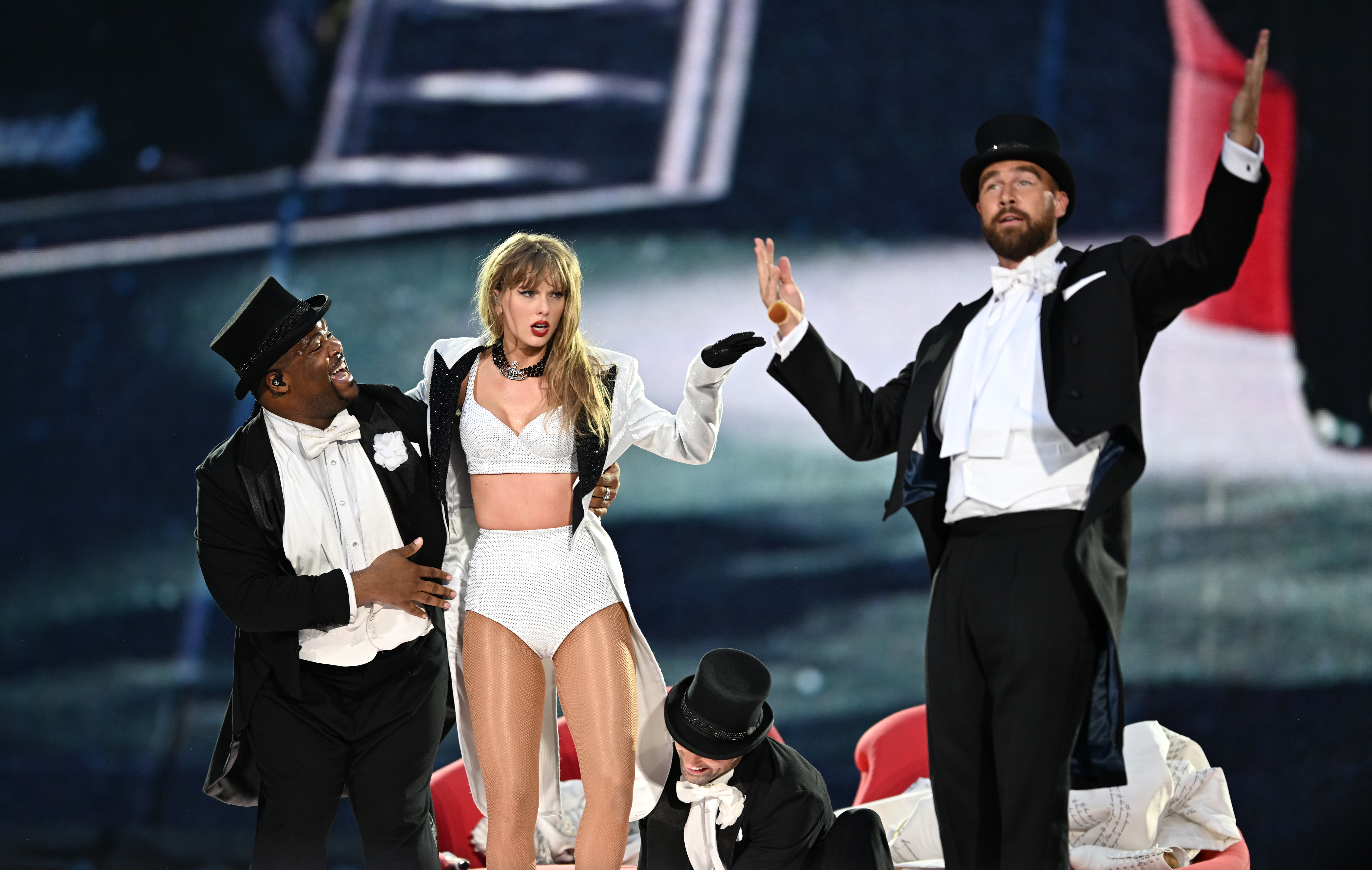 Travis Kelce and Taylor Swift perform on stage in London