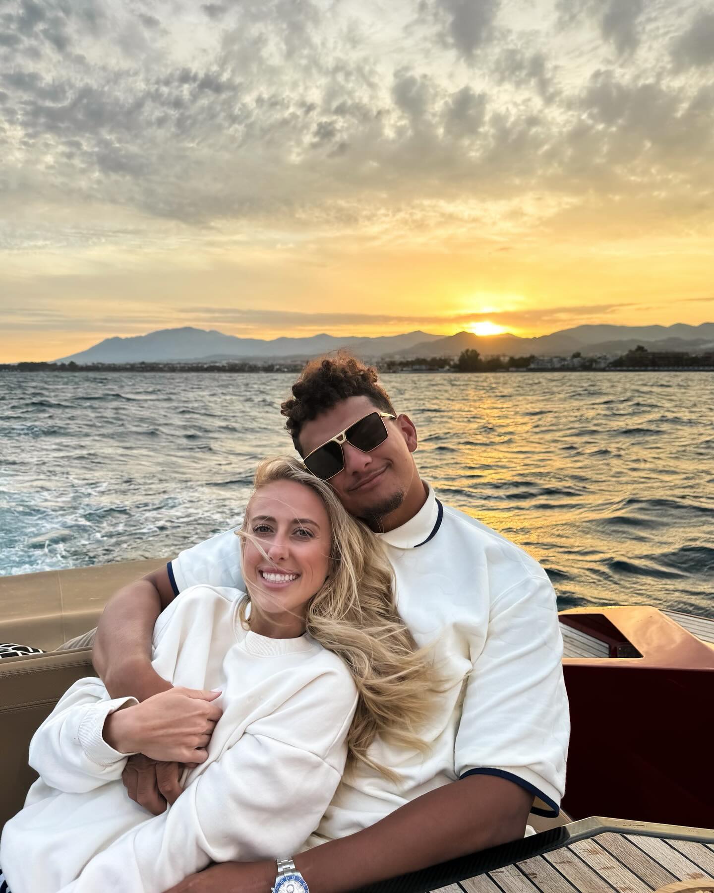 Patrick and Brittany pose for a picture with a beautiful sunset in the background