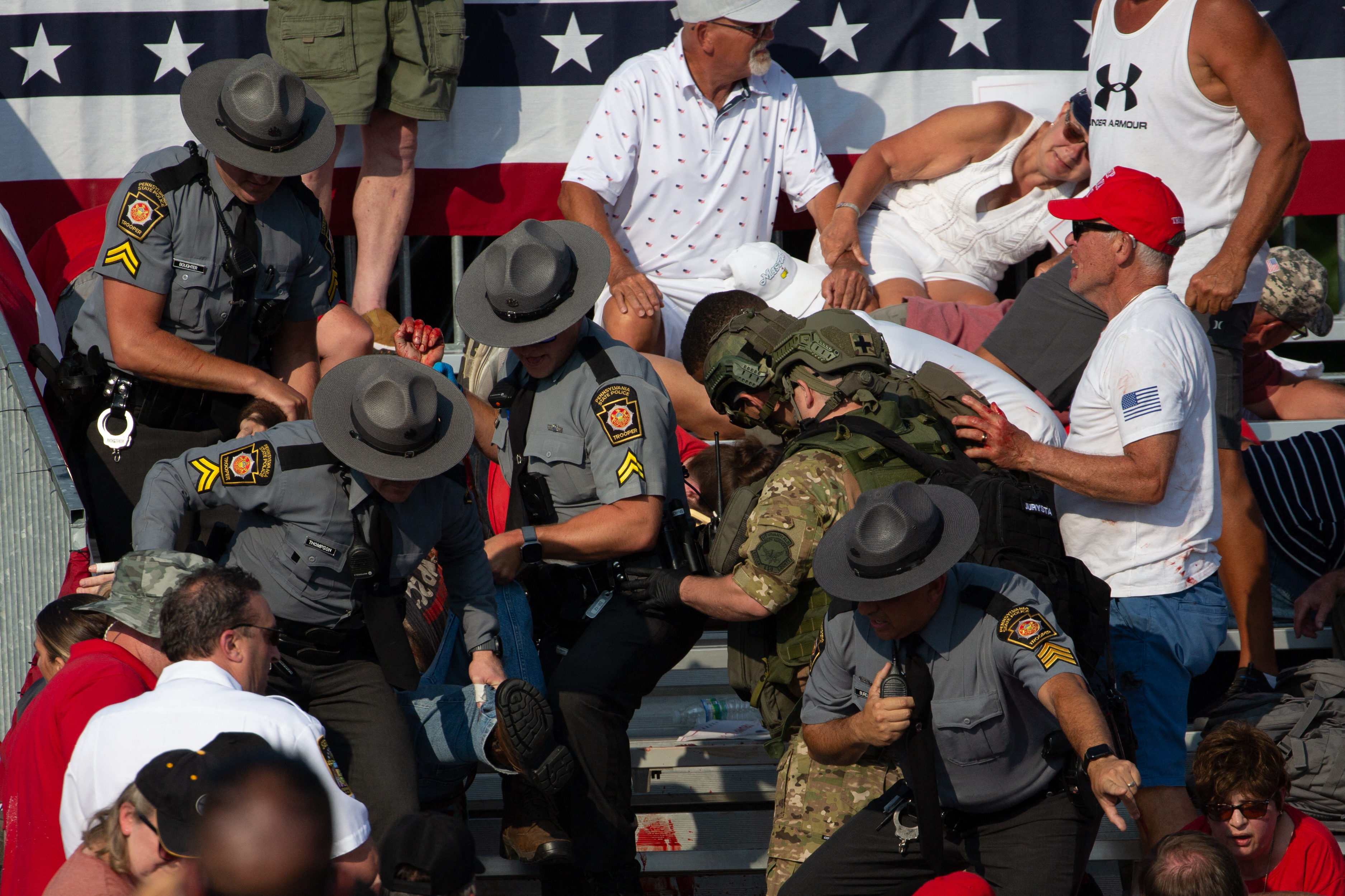 A person was pictured being removed by state police from the stands after shots were fired at Trump's campaign event