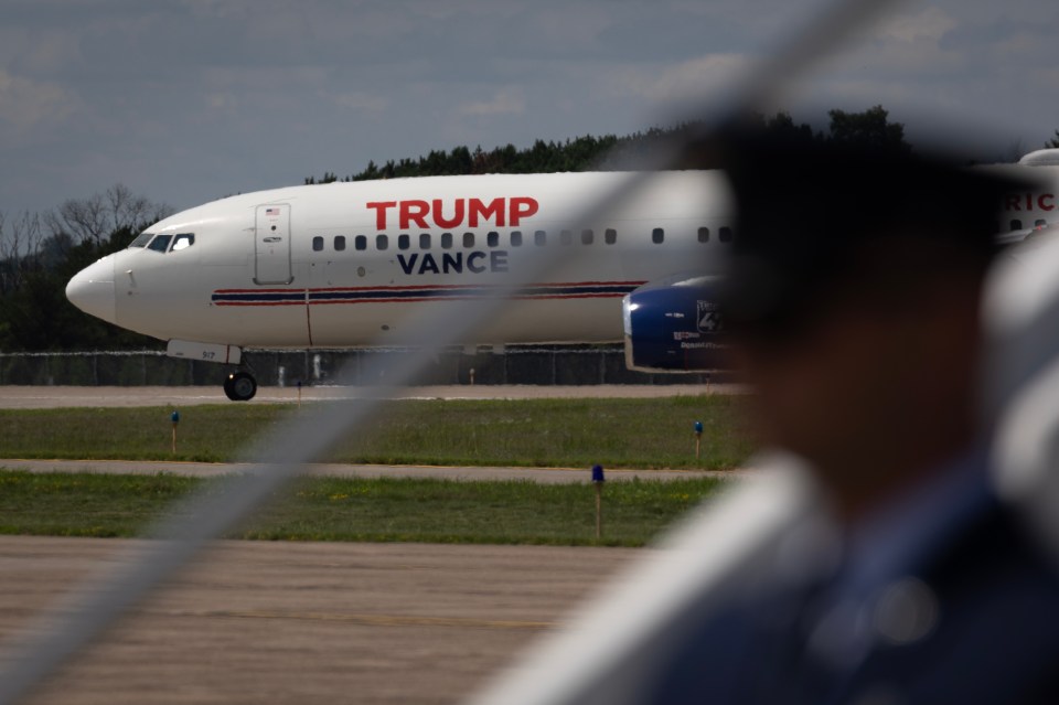 A plane carrying Ohio Senator JD Vance taxis past Air Force Two as Democratic presidential candidate Kamala Harris and her running mate Tim Walz arrive for a campaign rally on August 7, 2024, in Eau Claire, Wisconsin