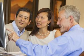 Couple looking at computer screen with their financial advisor