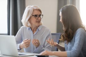 Two women chatting in front of a laptop