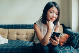 Young Woman Planning In Mind, Using Smartphone At Cafe