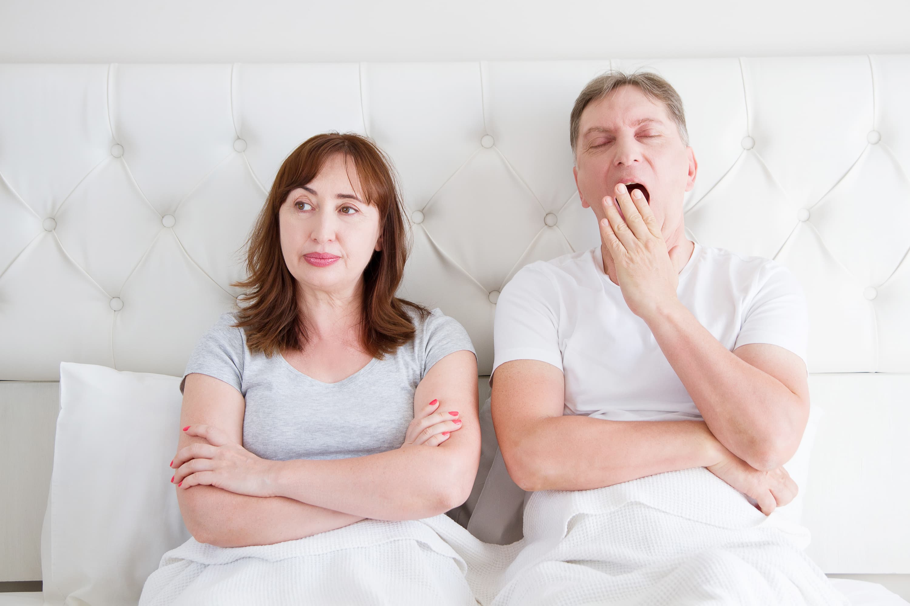 A middle-aged couple lay in bed. If they were having sex, he'd be much more likely to orgasm than his female partner.