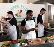 This is an image of three people preparing food in a kitchen