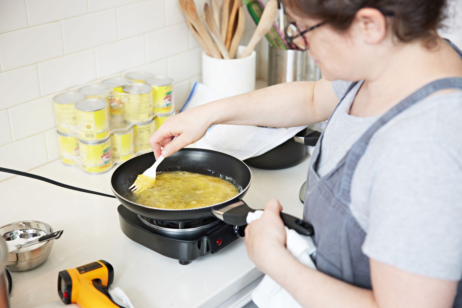 Woman cooking eggs in Farberware 15-Piece Dishwasher-Safe Nonstick Cookware Set