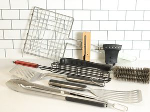 Several grilling tools we recommend displayed on a white counter