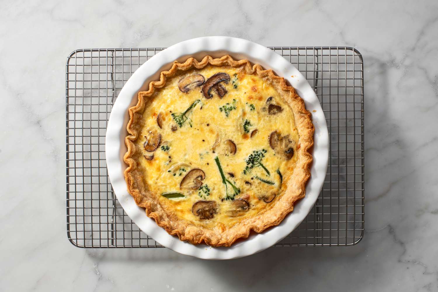 A baked quiche on a cooling rack