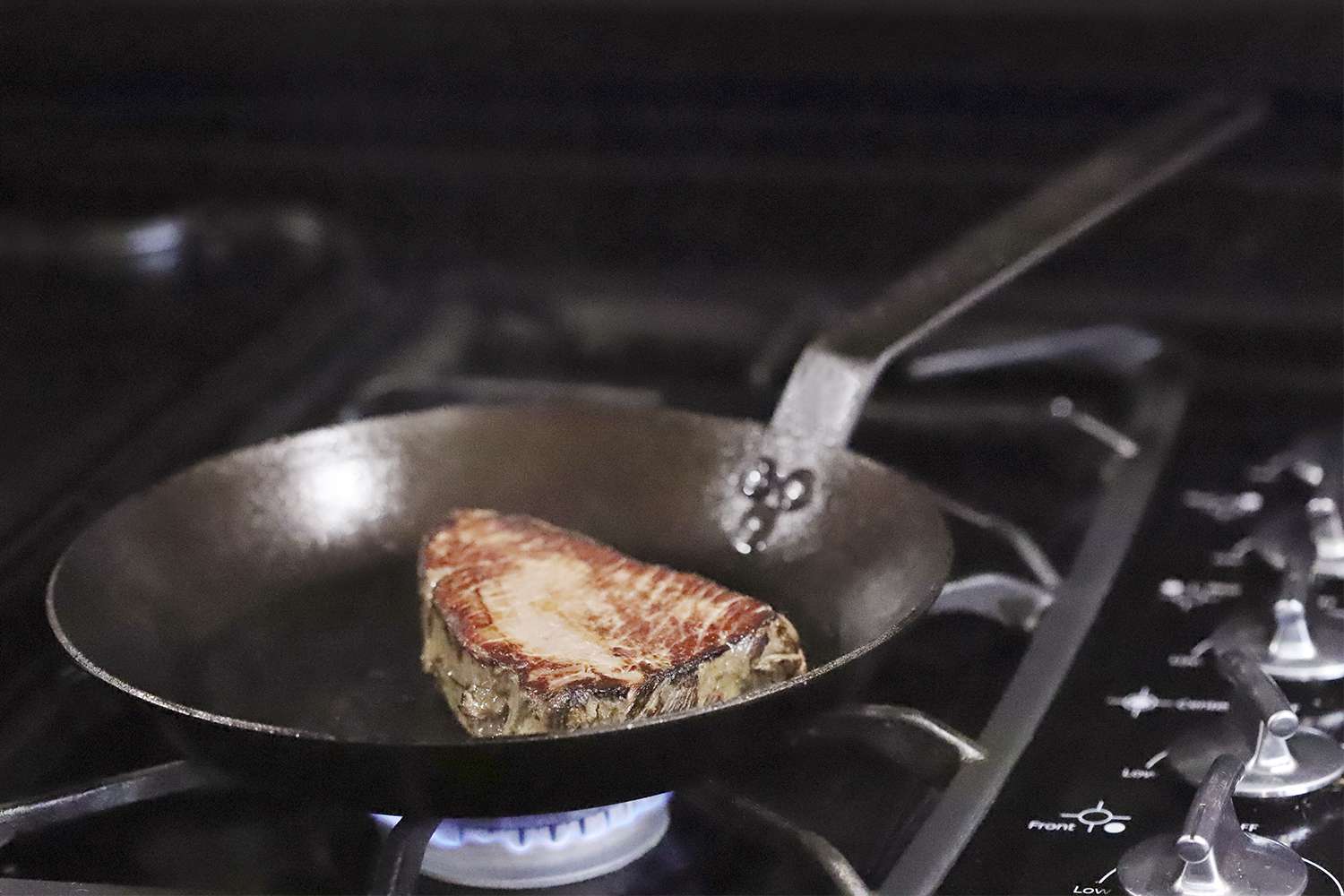 Lodge Seasoned Carbon Steel Skillet searing a steak on the stove 