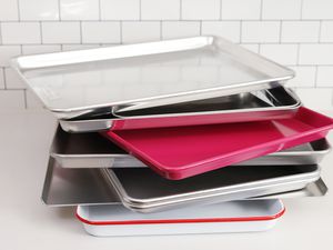 Stack of half sheet pans we recommend displayed on a white table