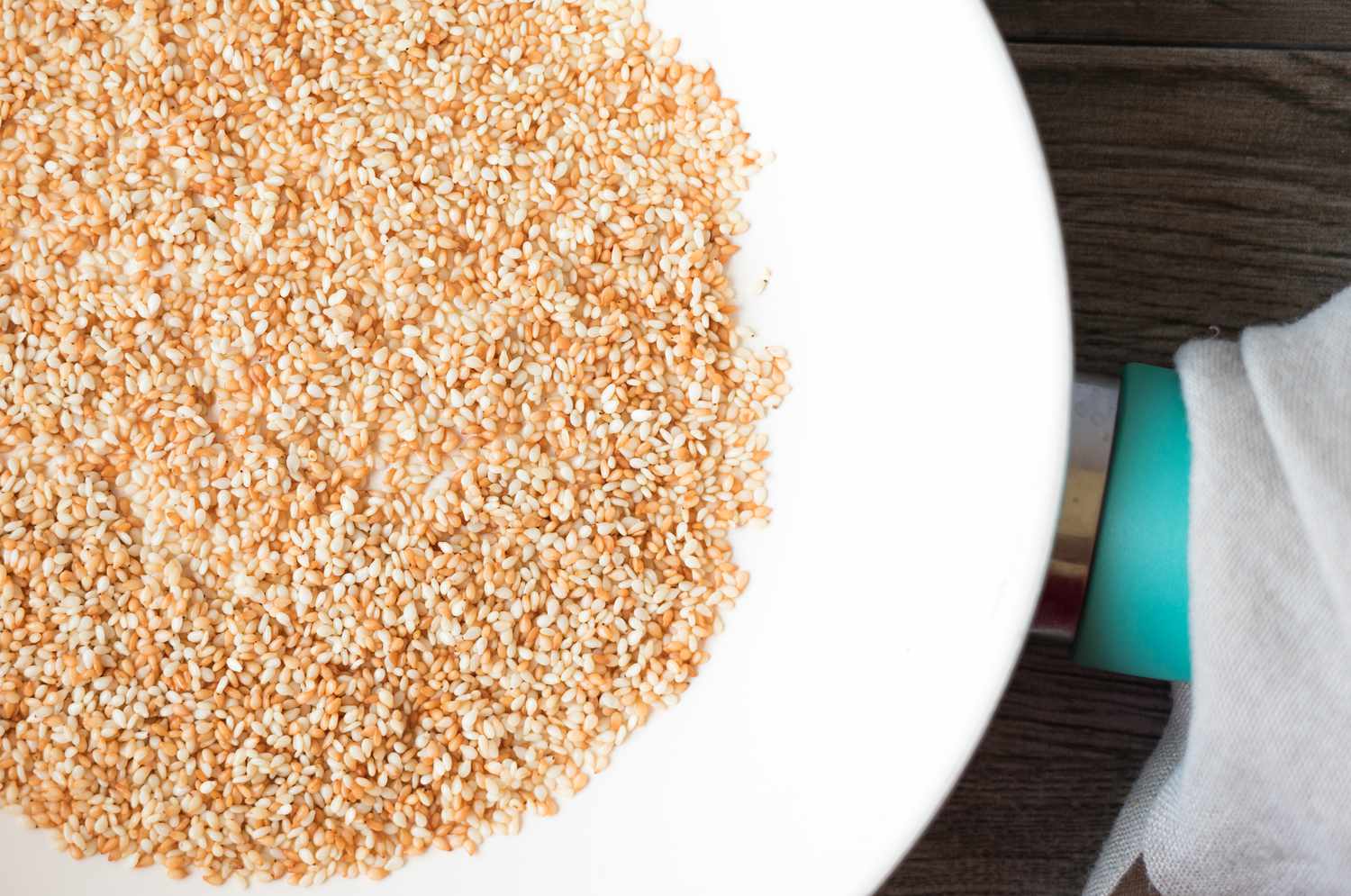 Sesame seeds toasting in a frying pan