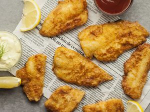 Easy fried fish fillets with tartar sauce, ketchup and lemon wedges