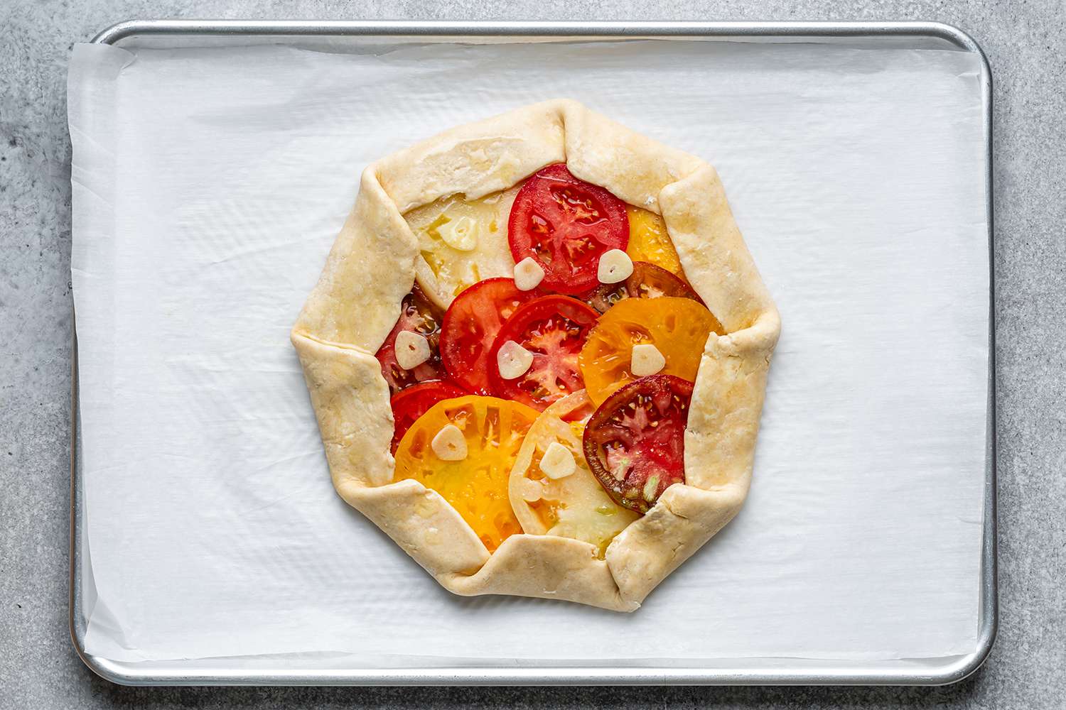 unbaked tomato galette on baking sheet