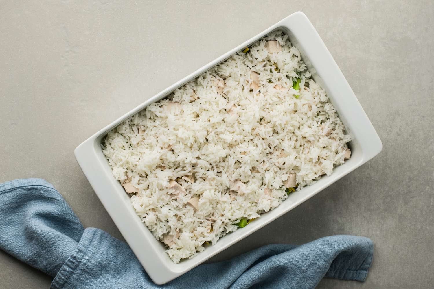 Cooked rice over chicken in a pan