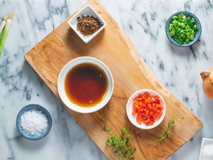 Jamaican jerk marinade and its ingredients on a wooden cutting board