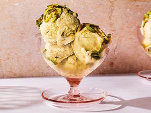 A glass bowl of pistachio no-churn ice cream topped with slivered pistachios