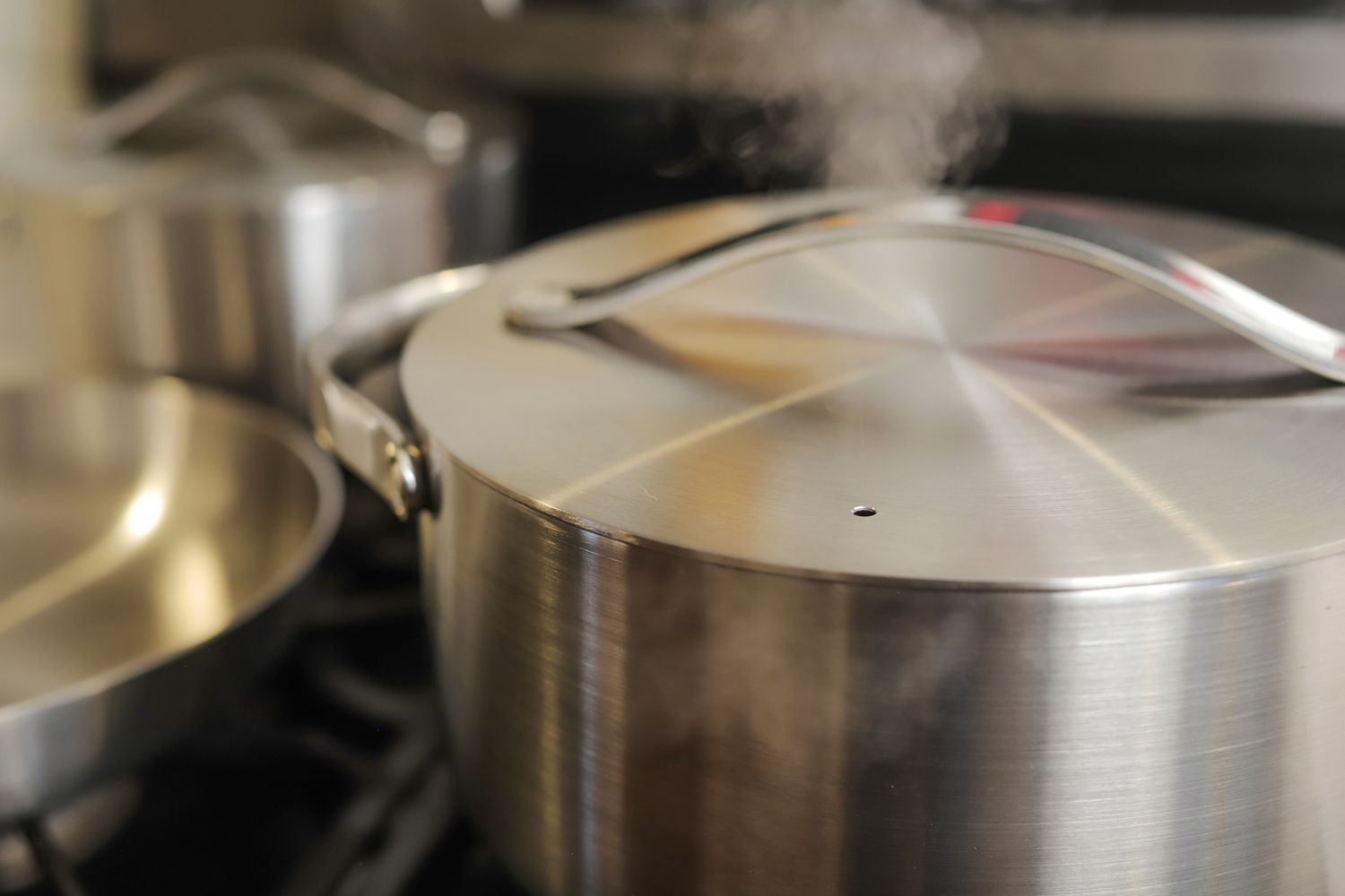 Steaming coming out of pot of Caraway Stainless Steel Cookware Set