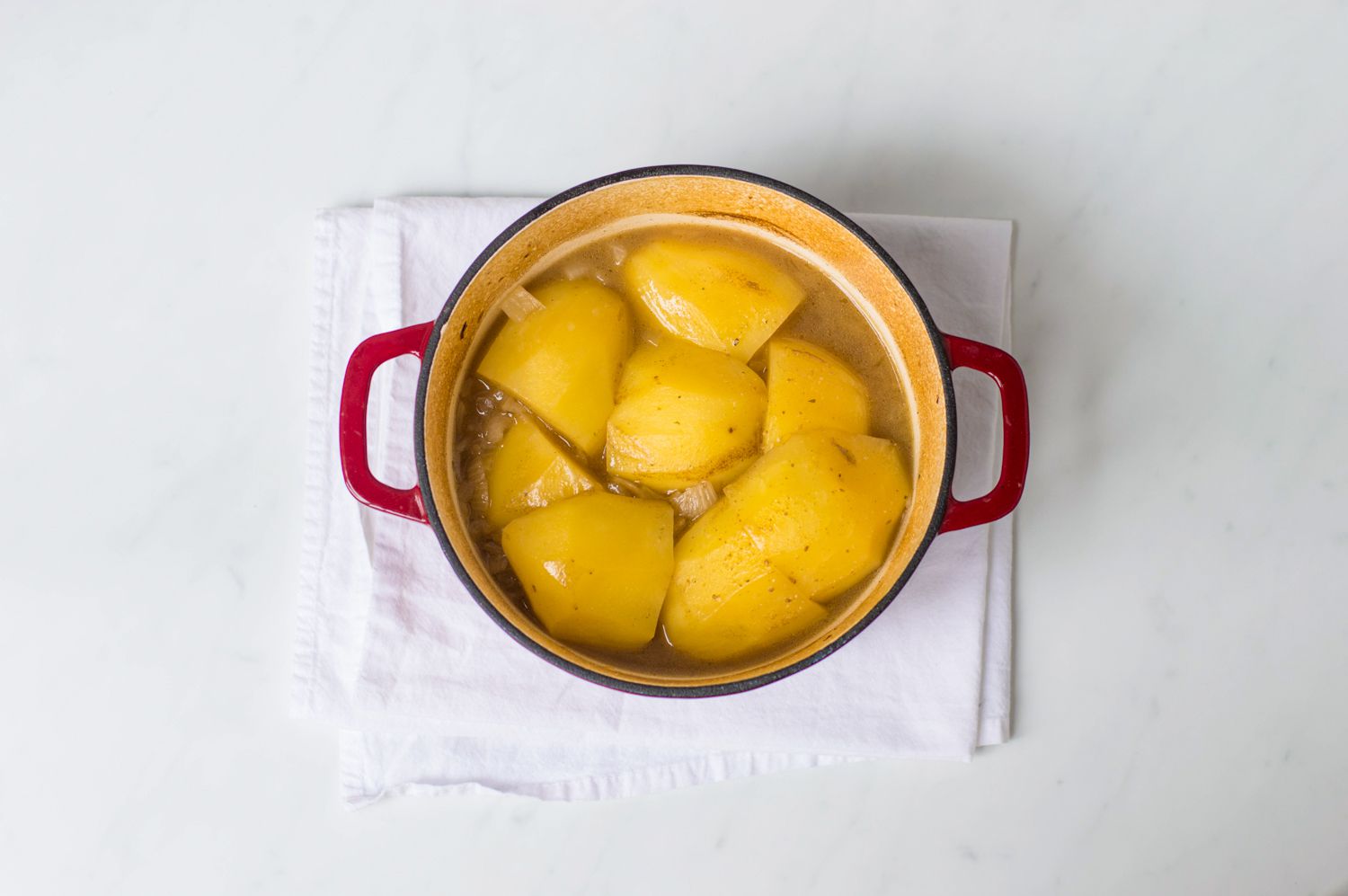 Potato layer in Scottish stovies in a Dutch oven