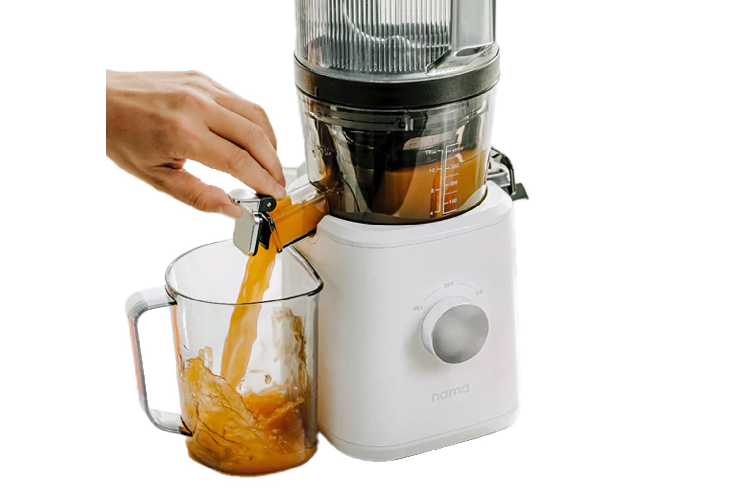 Hand dispensing juice from Nama J2 Cold Press Juicer