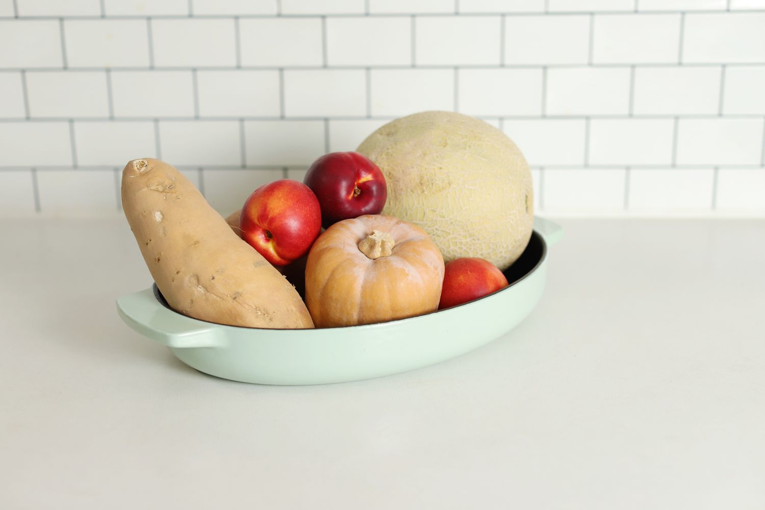 Vegetables in the KitchenAid oval cast iron roasting pan, on a counter