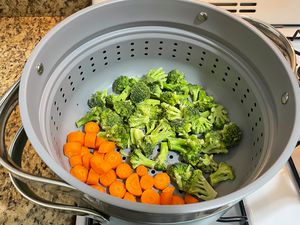 Carrots and broccoli in Caraway Steamer on kitchen counter