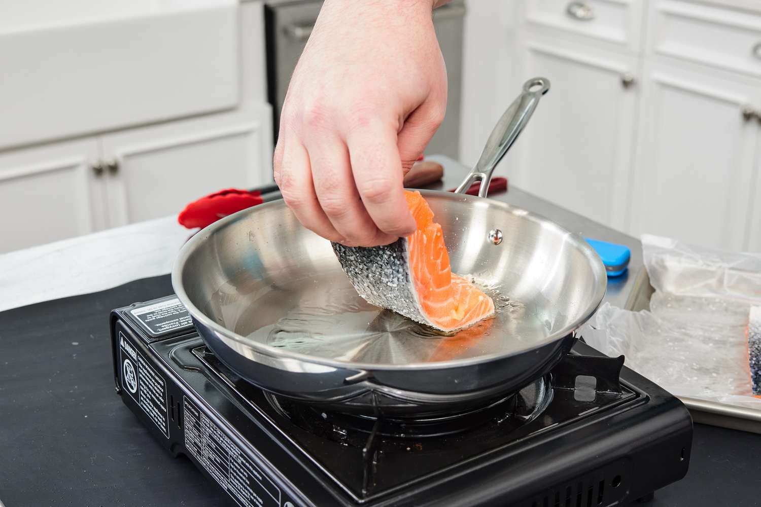 Placing a salmon filet into the Goldilocks pan during testing