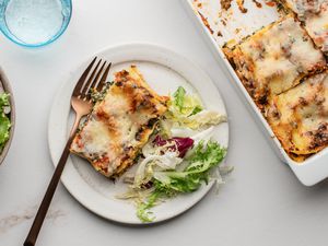Perfect spinach lasagna on a plate with salad greens