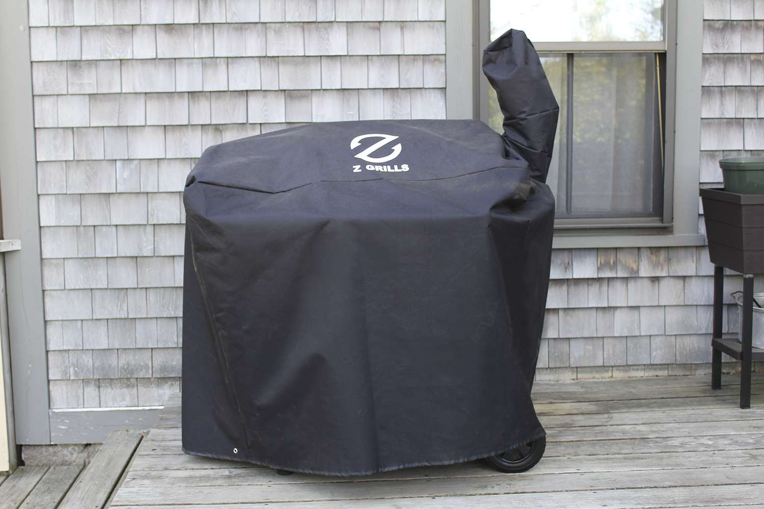 Z Grills ZPG-450A Wood Pellet Grill & Smoker with its cover on a wooden deck