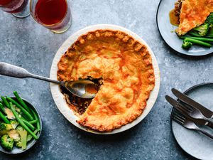 Ultimate steak and kidney pie in a pie dish with a big spoon