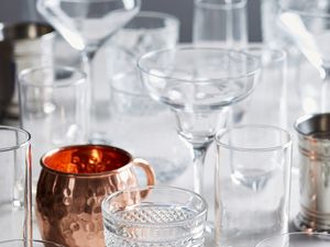 Collection of different types of bar glasses including rocks, mule, and margarita glasses.