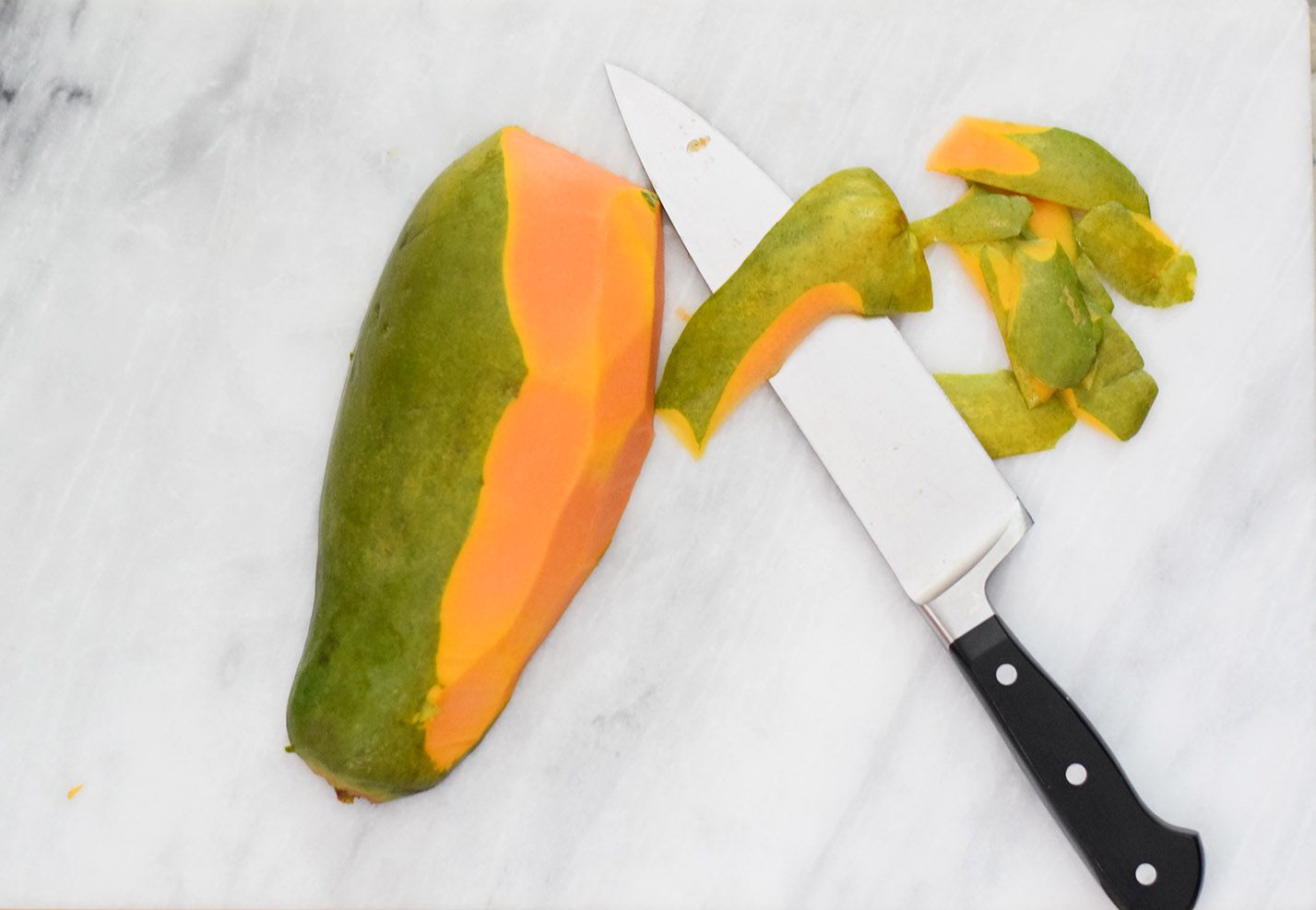 papaya half peeled with knife