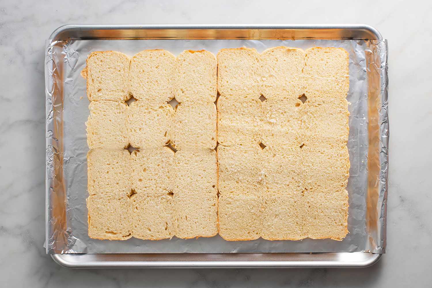 A large baking sheet with the bottom half of rolls