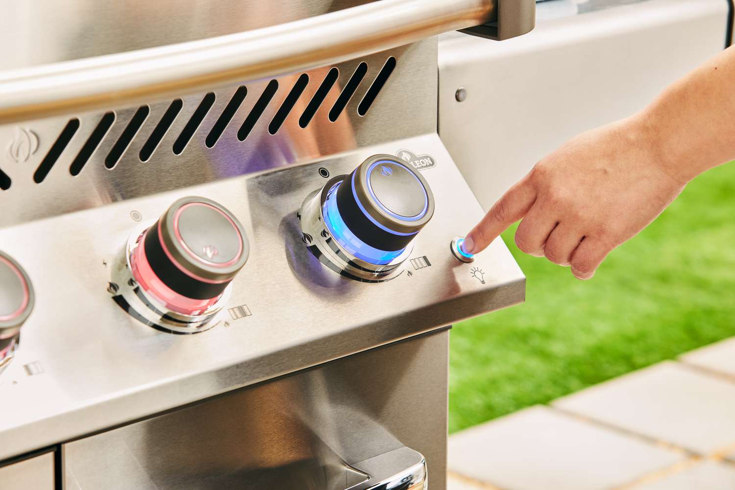 Hand pushing button on Napoleon Prestige 500 Propane Gas Grill