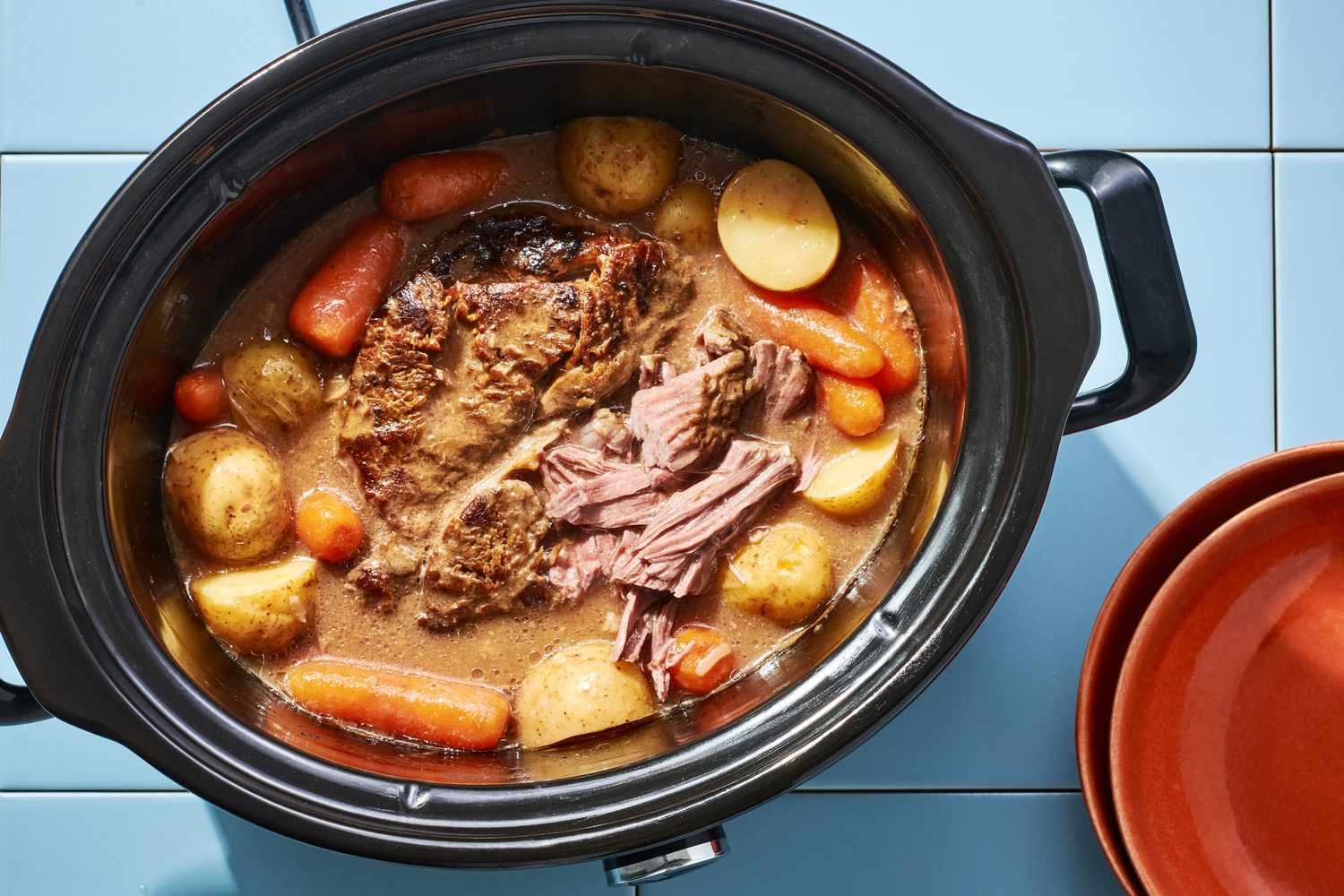 A slow cooker with onion soup beef pot roast, with potatoes and carrots