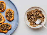 A small bowl of mushroom duxelles next to a plate of toasted crostini topped with mushroom duxelles